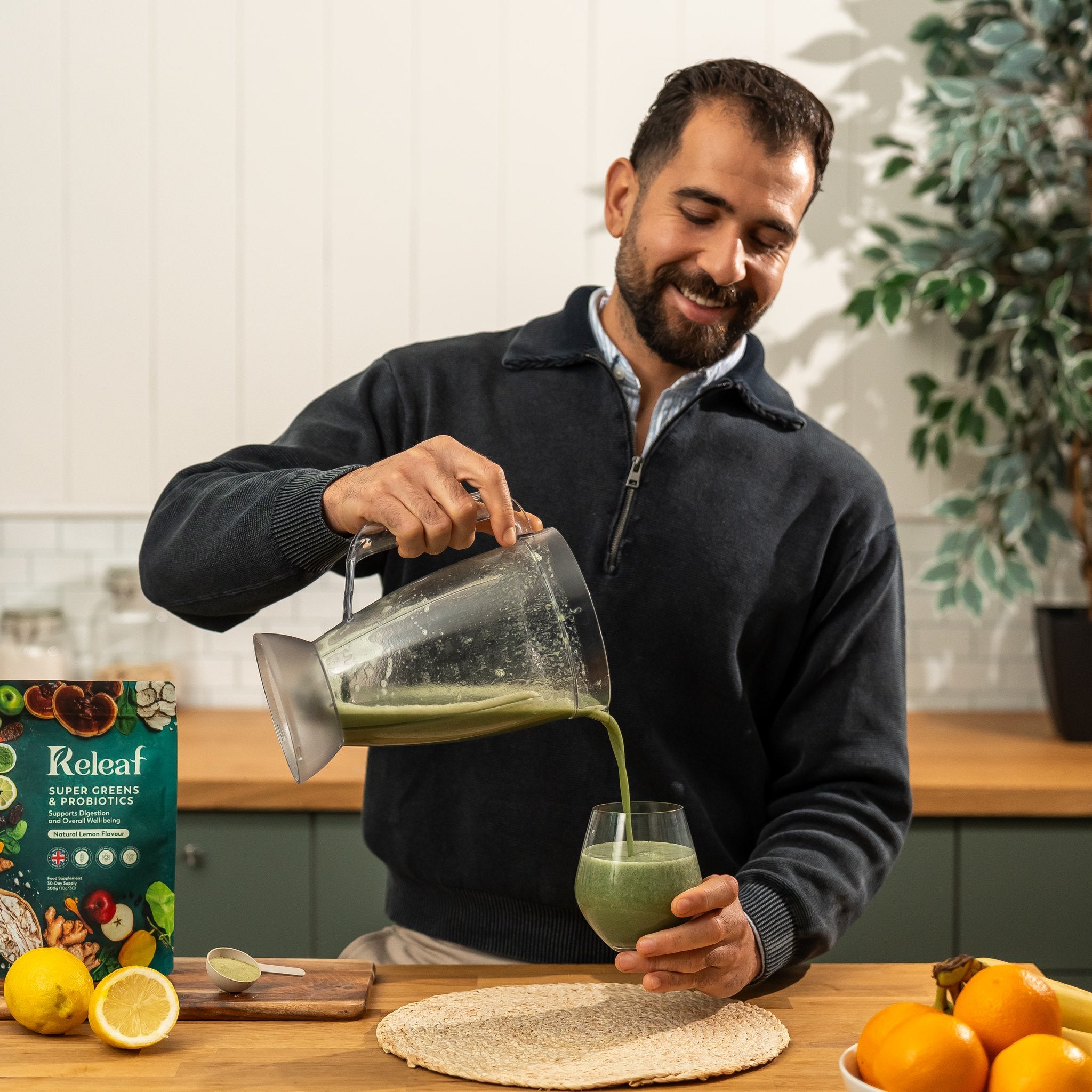 Releaf founder pouring a blended greens smoothie with fresh lemons on the counter