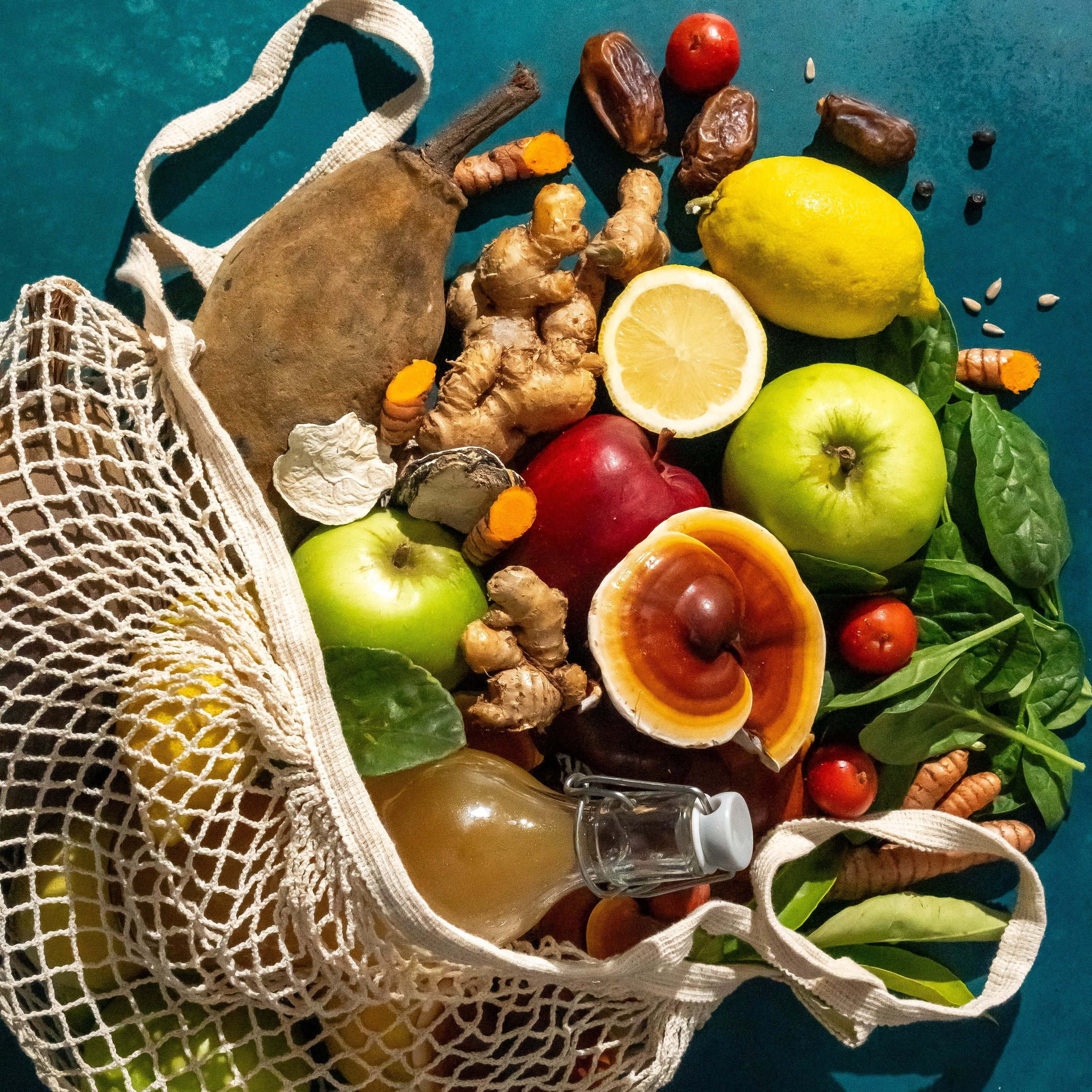 Flat lay of Releaf organic ingredients - baobab, ginger, turmeric, lemon, dates, apples, spinach, reishi and apple cider vinegar