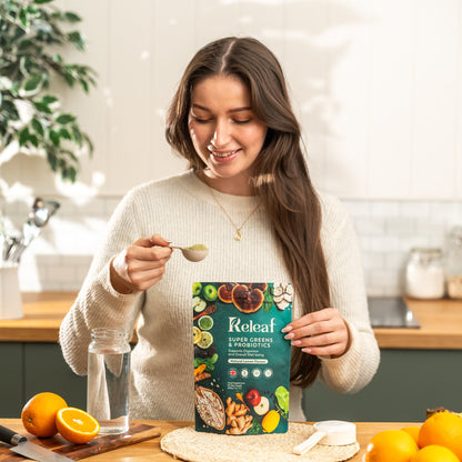 Woman preparing her daily Releaf Super Greens drink in a bright kitchen